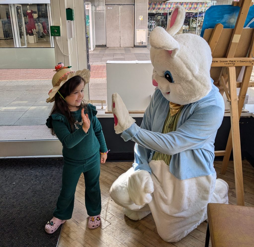 Photo of a child and the Easter bunny at the Easter bonnet making